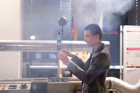 Ein Mann steht in einem Labor, im Hintergrund Nebel.